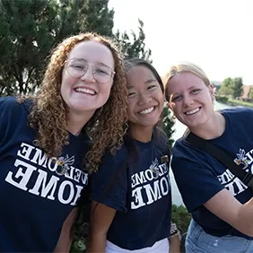 Three smiling students wearing 