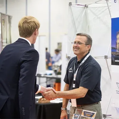 Student shaking employer's hand at career fair